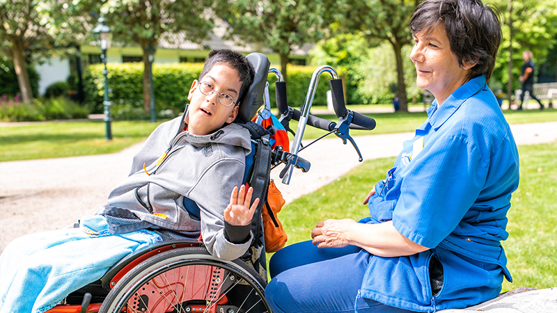 Traineeprogramm Gastkind und Mitarbeiter sitzen im Park